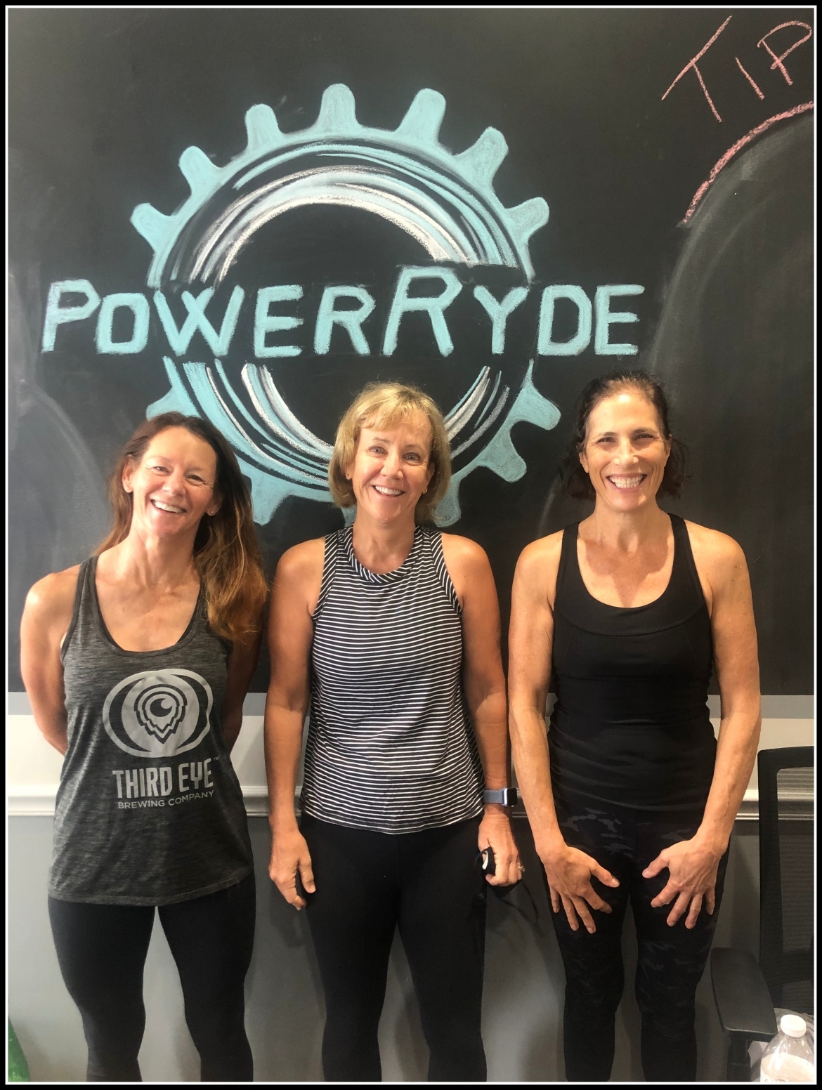 Jenny Lytle, Michelle Groene, and Susan Raftrey in front of chalk PowerRyde logo